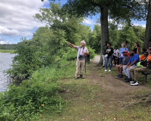 Mark Gallagher of Princeton pointing towards the wetland restoration site at Roebling Park explaining wetland restoration to group of youth